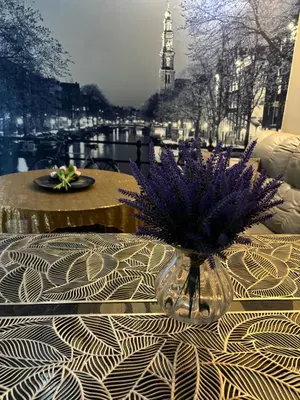 a vase with purple flowers sitting on a table at Modern 3BR with Iconic KLCC Towers Skyline Views and Parking in Kuala Lumpur