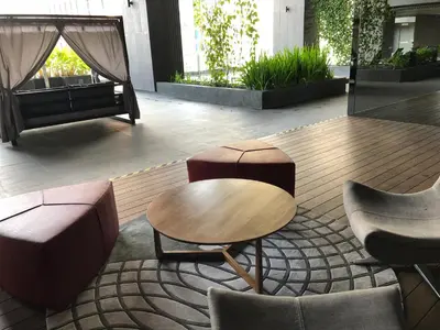 a group of chairs and tables in a lobby at Modern 3BR with Iconic KLCC Towers Skyline Views and Parking in Kuala Lumpur