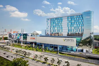 a large glass building with a highway in front of it at Vivatel Kuala Lumpur in Kuala Lumpur