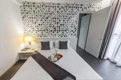 a bedroom with a white bed with a tray of food on it at Vivatel Kuala Lumpur in Kuala Lumpur