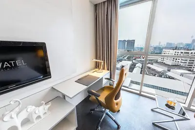 a hotel room with a desk with a tv and a chair at Vivatel Kuala Lumpur in Kuala Lumpur