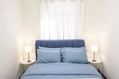 a bedroom with a blue bed with two lamps at Omar's Place 1 in Kuala Lumpur