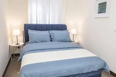 a blue and white bed in a room with two lamps at Omar's Place 1 in Kuala Lumpur