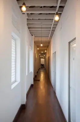 an empty hallway in an office building with white walls and wood floors at YWCA Kuala Lumpur in Kuala Lumpur
