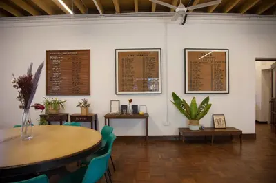 a dining room with tables and chairs and menus on the wall at YWCA Kuala Lumpur in Kuala Lumpur