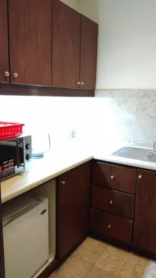 a kitchen with wooden cabinets and a sink and a microwave at KL Times Square Apartment in Kuala Lumpur