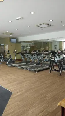 a gym with rows of tread machines in a room at KL Times Square Apartment in Kuala Lumpur