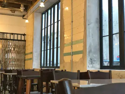 a dining room with tables and chairs and windows at Mingle Highstreet - CoWorking Hub in Kuala Lumpur