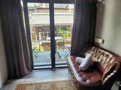 a brown leather couch in a room with a window at Mingle Highstreet - CoWorking Hub in Kuala Lumpur
