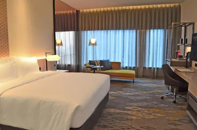 a hotel room with a large bed and a couch at EQ Kuala Lumpur in Kuala Lumpur