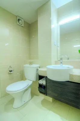 a bathroom with a toilet and a sink and a mirror at Wedgewood Residences in Kuala Lumpur