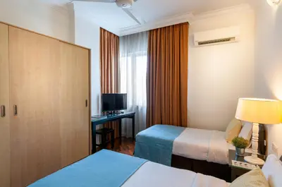 a hotel room with two beds and a television at Wedgewood Residences in Kuala Lumpur