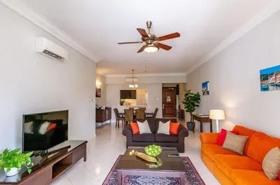 a living room with orange furniture and a flat screen tv at Wedgewood Residences in Kuala Lumpur