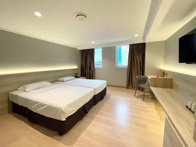 a hotel room with two beds and a flat screen tv at Hotel Imperial in Kuala Lumpur