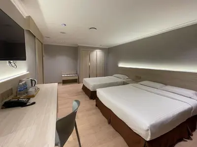 a hotel room with two beds and a desk at Hotel Imperial in Kuala Lumpur
