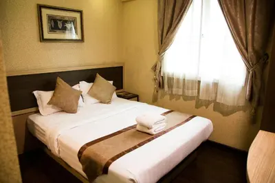 a hotel room with a bed with a window at Hotel Valenza in Kuala Lumpur