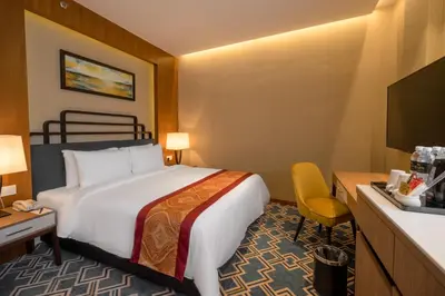 a hotel room with a bed and a television at MPalace Hotel KL in Kuala Lumpur