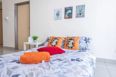 a bed with an orange pillow and pillows on it at PV21 Setapak, Wangsamaju, Melawati, 15min to KLCC B36a in Kuala Lumpur