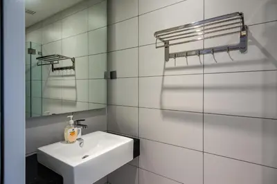 a white bathroom with a sink and a mirror at Anggun Residences Luxe in Kuala Lumpur