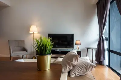 a living room with a table with pillows and a tv at Anggun Residences Luxe in Kuala Lumpur
