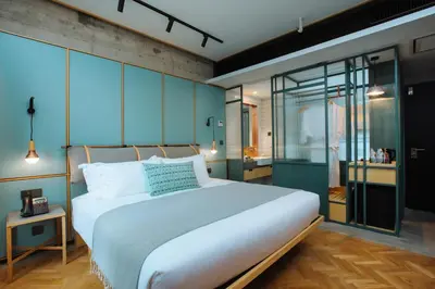 a bedroom with a large white bed with blue walls at KLoe Hotel in Kuala Lumpur