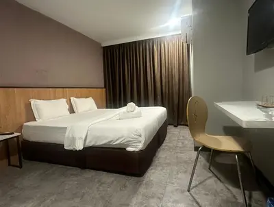 a hotel room with a bed and a chair at D'Garden Hotel Kuala Lumpur in Kuala Lumpur