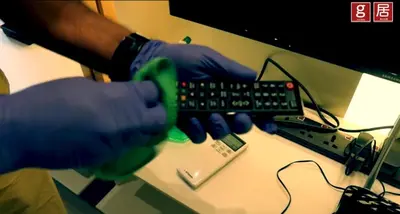 a person in gloves holding a remote control on a desk at EXPRESSIONZ KLCC by Gsuites in Kuala Lumpur