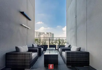 a balcony with wicker chairs and a glass table at EXPRESSIONZ KLCC by Gsuites in Kuala Lumpur