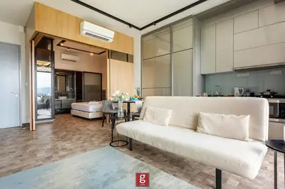 a living room with a white couch and a kitchen at EXPRESSIONZ KLCC by Gsuites in Kuala Lumpur