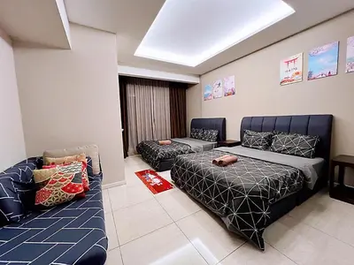 a living room with two beds and a couch at Dorsett Residences Sri Hartamas KL in Kuala Lumpur
