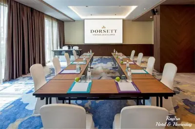 a conference room with a long table and white chairs at Dorsett Residences Sri Hartamas in Kuala Lumpur