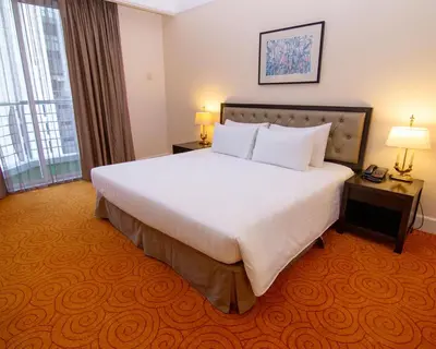 a hotel room with a large bed and a window at Perdana Kuala Lumpur City Centre in Kuala Lumpur