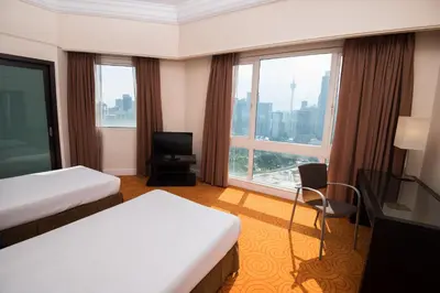a hotel room with two beds and a large window at Perdana Kuala Lumpur City Centre in Kuala Lumpur