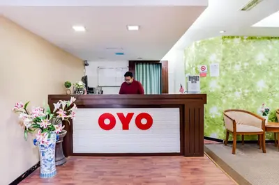 a man is standing at a counter in a restaurant at OYO 89652 Bjorn Boutique Hotel in Kuala Lumpur