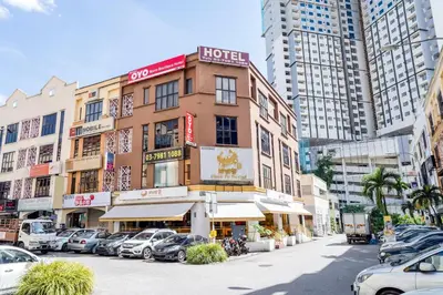 a building with cars parked in a parking lot at OYO 89652 Bjorn Boutique Hotel in Kuala Lumpur
