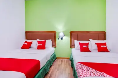 two beds with red pillows in a room at OYO 89652 Bjorn Boutique Hotel in Kuala Lumpur