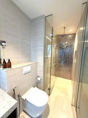 a bathroom with a toilet and a glass shower at Star Residences KLCC in Kuala Lumpur