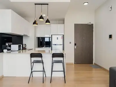 two bar stools in a kitchen with white cabinets at Star Residences KLCC in Kuala Lumpur