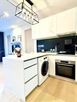 a kitchen with white cabinets and a washer and dryer at Star Residences KLCC in Kuala Lumpur