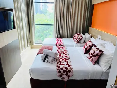 a hotel room with two beds with pillows on them at Prime Hotel at TRX Tower in Kuala Lumpur