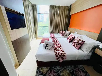 a hotel room with two beds with pillows on them at Prime Hotel at TRX Tower in Kuala Lumpur