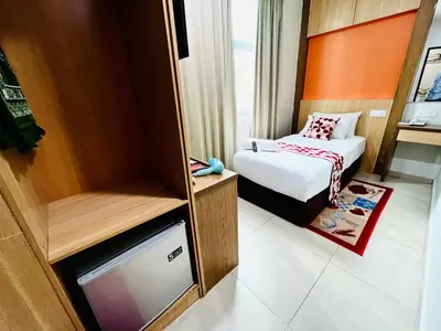 a small room with a bed and a tv at Prime Hotel at TRX Tower in Kuala Lumpur