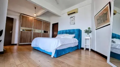 a bedroom with a large bed and a blue headboard at Penthouse on 34 - The Highest Unit and Best Views in Regalia & Private Rooftop Terrace in Kuala Lumpur