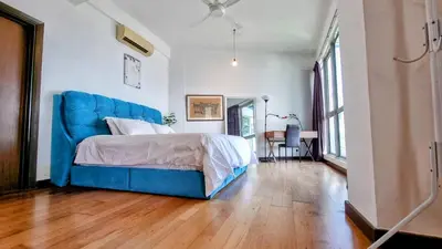 a bedroom with a blue bed and a wooden floor at Penthouse on 34 - The Highest Unit and Best Views in Regalia & Private Rooftop Terrace in Kuala Lumpur