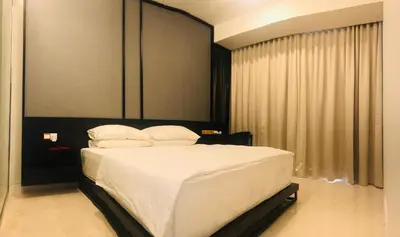 a bedroom with a bed with white sheets and pillows at Tropicana The Residence, KLCC in Kuala Lumpur