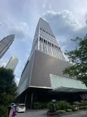 a tall building with a bus parked in front of it at Tropicana The Residence, KLCC in Kuala Lumpur