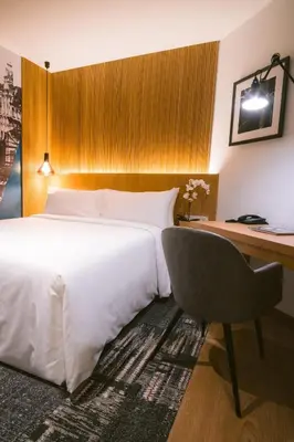 a bedroom with a bed and a desk and a chair at Indie Hotel Kuala Lumpur in Kuala Lumpur