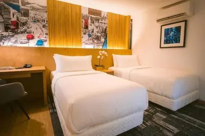 a hotel room with two beds and a desk at Indie Hotel Kuala Lumpur in Kuala Lumpur