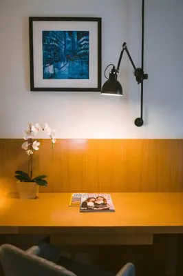 a desk with a book and a lamp on it at Indie Hotel Kuala Lumpur in Kuala Lumpur