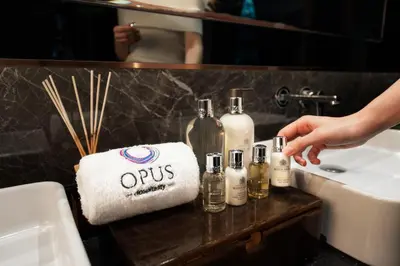 a bathroom counter with bottles of alcohol and a towel at Opus Residences by Opus Hospitality in Kuala Lumpur